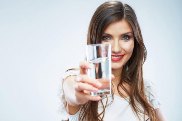 Девушка держит стакан с водой