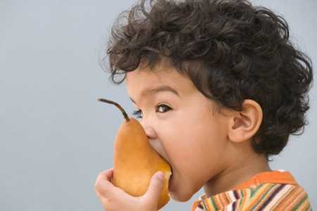 Ребенок ест грушу